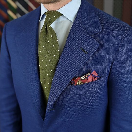 Mėlynas švarkas, šviesiai mėlyni marškiniai, žalias taškuotas kaklaraištis
