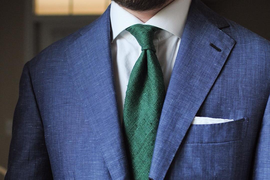 Mėlynas švarkas, balti marškiniai, žalias kaklaraištis