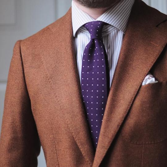 Oranžinis švarkas, šviesiai rudi dryžuoti marškiniai, violetinis taškuotas kaklaraištis