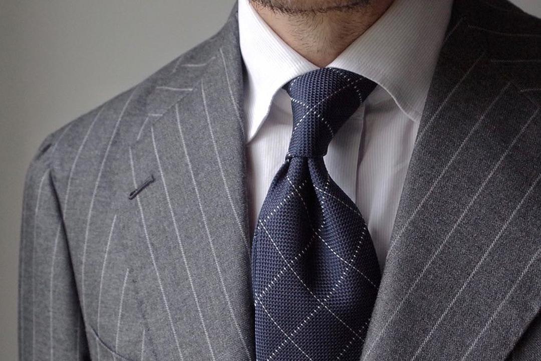 Balti marškiniai, pilkas kostiumas, mėlynas kaklaraištis