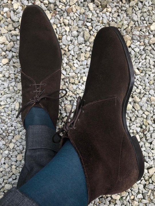 Pilkos kelnės, mėlynos kojinės ir rudi batai