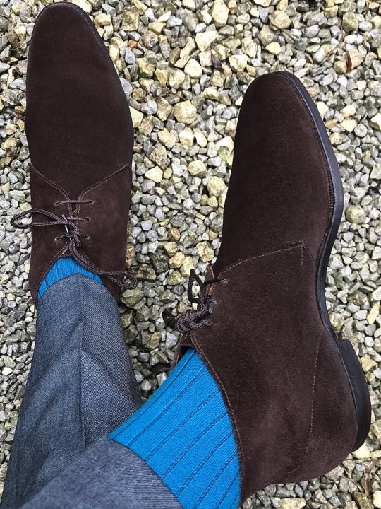 Pilkos kelnės, šviesiai mėlynos kojinės, rudi batai