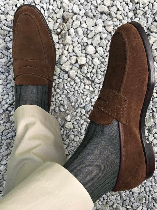 Šviesios kelnės, pilkos kojinės ir rudi batai