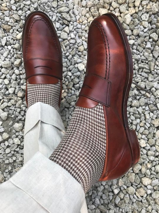 Šviesios kelnės, šviesios kojinės ir rudi batai