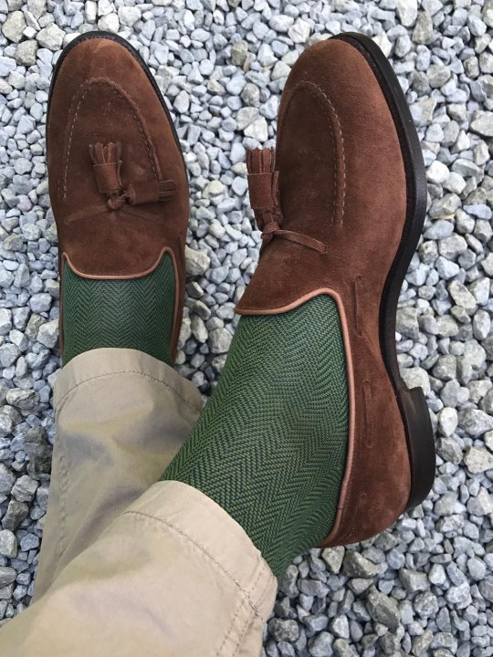 Šviesios kelnės, žalios kojinės ir rudi batai
